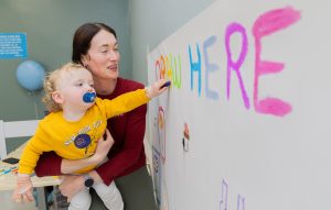 Patient drawing on board with parent for International Day of Play at Children's Health Ireland