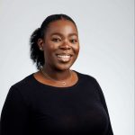 Jumoke-1: "Professional headshot of Jumoke, a smiling woman in a black top."