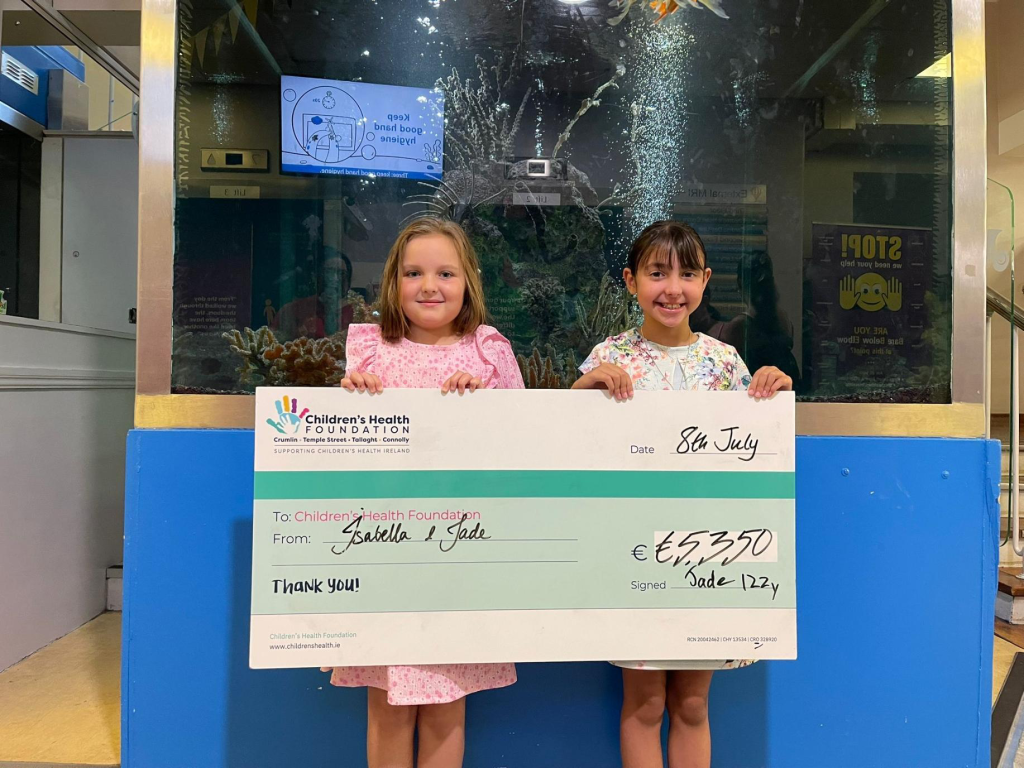 Jade and Isabella presenting a cheque after their kitchen tea fundraiser for Rheumatology and the Giggle Fund at CHI Crumlin.